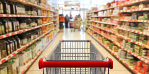 shopping-trolley-empty-with-red-handle-on-blur